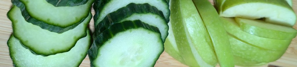 Image of fresh produce which can be used as high-value treats for guinea pigs - photo specifically has slices of cucumber and apple.